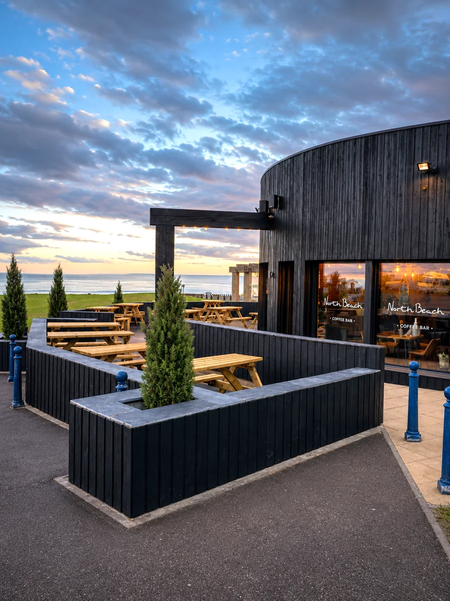 North Beach Coffee Bar terrace with outdoor tables and sea views at sunset